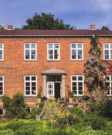 Frontansicht des Gutshauses in Dönkendorf in traditioneller Backsteinarchitektur.