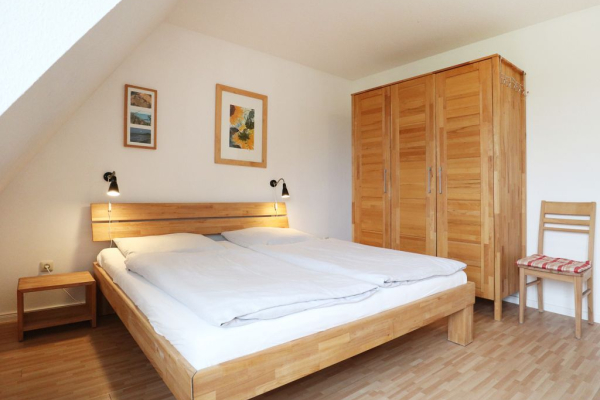 Blick in das große Schlafzimmer mit einem Doppelbett und einem Kleiderschrank