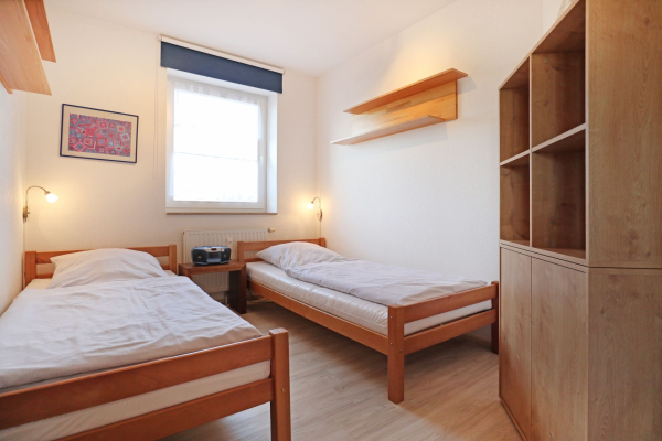Blick in das Kinder-/ Gästezimmer mit 2 Einzelbetten und einem Regal