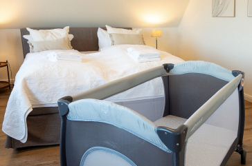 Das Reethaus - Blick in das Schlafzimmer mit dem Kinderreisebett