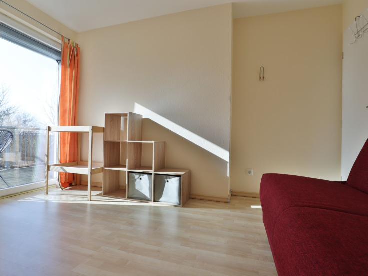 Strandgut Ferienhaus - Blick in das Gästezimmer mit Babybett und Wickeltisch