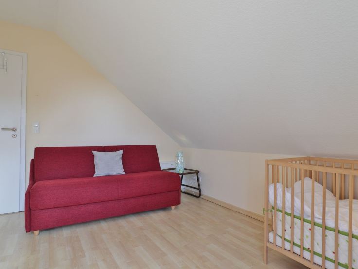Strandgut Ferienhaus - Blick in das Gästezimmer mit Babybett und Wickeltisch