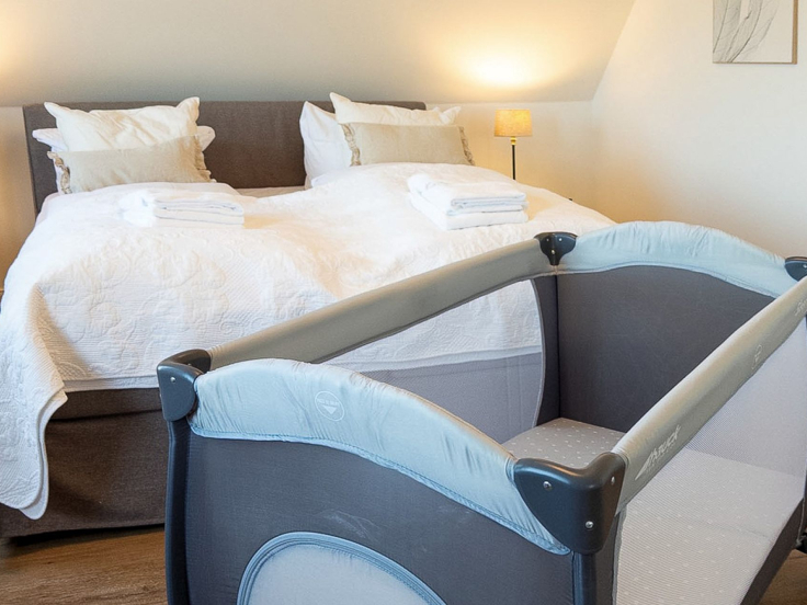 Das Reethaus - Blick in das Schlafzimmer mit dem Kinderreisebett