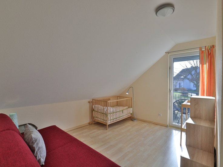 Strandgut Ferienhaus - Blick in das Gästezimmer mit Babybett und Wickeltisch