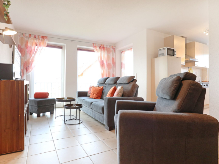 Blick auf das Sofa und den Hocker mit zwei kleinen Tischen