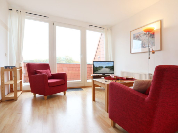 Blick auf den offenen Wohnbereich mit Sessel, Sofa und Fernseher