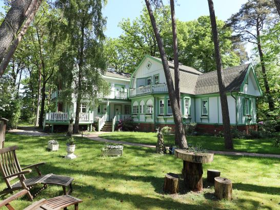 Eine histirusche Villa in einer Grünanlage.
