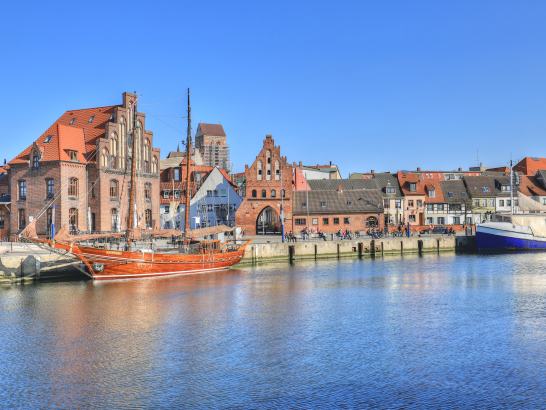 Wismar von der Kaikante aus. Im Hintergrund Boote und Speicherhäuser.