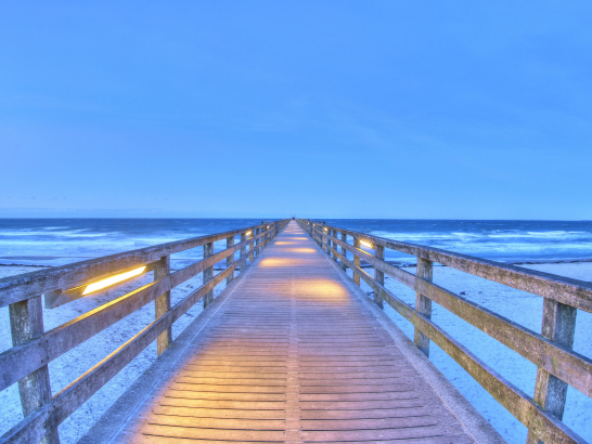 Beleuchtete Seebrücke in Boltenhagen im Winter mit Blick auf die Ostsee