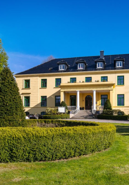 Ein Gutshaus in einem Park.