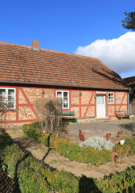 Ein Fachwerkhaus mit einem Garten davor. 